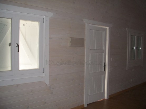 Una pared de madera con pintura blanca y vetas de madera.